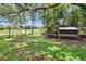 Large fenced yard with well maintained grass and a custom chicken coop provides a safe space for outdoor activities at 1110 Mercer Loop, Plant City, FL 33567