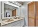 Bathroom with double sinks with marble counters, wooden doors and large mirror at 1110 Mercer Loop, Plant City, FL 33567