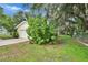 View of the home's exterior with a well maintained lawn, mature trees, and an attached garage at 1110 Mercer Loop, Plant City, FL 33567
