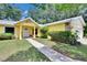 Well-maintained yellow house featuring a walkway leading to the entrance at 1110 Mercer Loop, Plant City, FL 33567