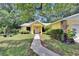 Charming yellow home with stone accents, mature trees and inviting front lawn at 1110 Mercer Loop, Plant City, FL 33567