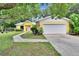 Charming yellow home with white garage door, stone accents, and inviting landscaped front yard at 1110 Mercer Loop, Plant City, FL 33567