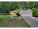 Charming yellow home featuring a white garage door, stone accents, and lush landscaping at 1110 Mercer Loop, Plant City, FL 33567
