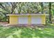 Front view of the detached yellow garage showing two doors and a concrete parking pad at 1110 Mercer Loop, Plant City, FL 33567