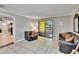 Cozy living room features neutral tones, tile flooring, comfortable seating, and sliding door access at 1110 Mercer Loop, Plant City, FL 33567