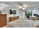 Large bedroom with ceiling fan, TV, wood dresser and an adjacent bathroom at 1110 Mercer Loop, Plant City, FL 33567