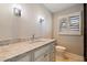 Bathroom vanity features a granite countertop, white cabinets, and contemporary lighting at 11225 4Th E St, Treasure Island, FL 33706