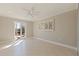Light-filled bedroom with tile floors, ceiling fan, shutters, and french doors leading to the outdoor area at 11225 4Th E St, Treasure Island, FL 33706