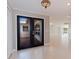 Open entryway features neutral tile flooring and glass paneled double doors into the home at 11225 4Th E St, Treasure Island, FL 33706
