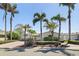 Inviting single-story home featuring a well-manicured lawn and mature palm trees at 11225 4Th E St, Treasure Island, FL 33706