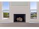 Bright living room features a modern fireplace, waterfront view, and natural light from the adjacent windows at 11225 4Th E St, Treasure Island, FL 33706