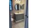 Well-lit bathroom with a modern vanity, round mirror, and updated fixtures at 11941 Skylake Pl # 11941, Temple Terrace, FL 33617