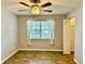 Well-lit bedroom featuring a ceiling fan, wood floors, and a window with cloth curtains at 11941 Skylake Pl # 11941, Temple Terrace, FL 33617