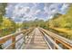 Picturesque view of a wooden bridge surrounded by lush greenery and water at 11941 Skylake Pl # 11941, Temple Terrace, FL 33617