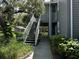 Exterior view showing stairs leading to second floor unit, surrounded by lush greenery and mature trees at 11941 Skylake Pl # 11941, Temple Terrace, FL 33617
