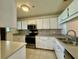 Well-lit kitchen with white cabinetry, stainless steel appliances, and tile backsplash at 11941 Skylake Pl # 11941, Temple Terrace, FL 33617