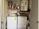 A functional utility room with washer, dryer, shelving with paint supplies, and a water heater at 11941 Skylake Pl # 11941, Temple Terrace, FL 33617
