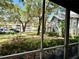 Screened-in patio with a view of lush landscaping, mature trees, and a parking area at 11941 Skylake Pl # 11941, Temple Terrace, FL 33617
