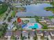 Community aerial showcasing a swimming pool, tennis courts, pond, clubhouse and lush landscaping at 12017 Gillingham Harbor Ln, Gibsonton, FL 33534