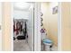 Well-lit bathroom featuring a toilet with blue seat, closet and floral decorations at 12017 Gillingham Harbor Ln, Gibsonton, FL 33534