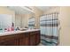 Well-lit bathroom featuring double sinks and a shower with stylish curtain at 12017 Gillingham Harbor Ln, Gibsonton, FL 33534