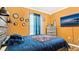 Bedroom with a comfy looking bed with blue bedding, bright orange walls, and a dresser underneath a flat screen tv at 12017 Gillingham Harbor Ln, Gibsonton, FL 33534