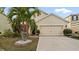 Charming home featuring a well-manicured lawn and two-car garage with a stylish design at 12017 Gillingham Harbor Ln, Gibsonton, FL 33534