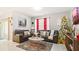 Living room featuring a sectional sofa, soft rug, Christmas tree, and a sliding glass door for natural light at 12017 Gillingham Harbor Ln, Gibsonton, FL 33534