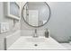 Modern bathroom with a white vanity, round mirror, and stainless steel faucet at 1320 Oak Valley Dr, Seffner, FL 33584