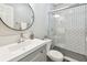 Modern bathroom with a white vanity, round mirror, and tiled shower at 1320 Oak Valley Dr, Seffner, FL 33584