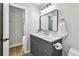 Stylish bathroom showcasing a vanity with gray cabinets, white countertop, and black patterned flooring at 1320 Oak Valley Dr, Seffner, FL 33584
