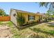 Side view of a yellow single-Gathering home with black shutters, and landscaping at 1320 Oak Valley Dr, Seffner, FL 33584