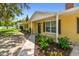 Lovely home featuring a yellow exterior, black shutters, landscaped garden, and paved walkway at 1320 Oak Valley Dr, Seffner, FL 33584