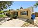 Well-kept single-Gathering home with a yellow exterior, black shutters, landscaping, and a concrete driveway at 1320 Oak Valley Dr, Seffner, FL 33584