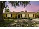 Charming single-story home featuring a yellow exterior, black shutters, and landscaped front yard at 1320 Oak Valley Dr, Seffner, FL 33584