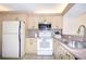 Bright kitchen featuring stainless steel microwave and white appliances at 14130 Rosemary Ln # 4215, Largo, FL 33774