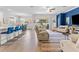 Open living space with blue accent wall, modern furniture, and seamless access to the outdoor patio at 17418 Holly Well Ave, Wimauma, FL 33598