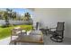 Covered patio features comfortable seating overlooking a well-maintained lawn and privacy fence at 17418 Holly Well Ave, Wimauma, FL 33598