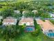 An aerial view of a home showcasing a screened-in pool, well-maintained lawn, and lush green surroundings at 18004 Avalon Ln, Tampa, FL 33647