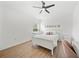 Bright bedroom with hardwood floors, natural light from the window, a desk, and white furniture at 18004 Avalon Ln, Tampa, FL 33647