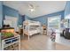Bright bedroom featuring a bunk bed, wood-look floors, and an abundance of natural light and blue accent walls at 18004 Avalon Ln, Tampa, FL 33647