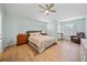 Comfortable bedroom with hardwood floors, a ceiling fan, natural light and a reading chair at 18004 Avalon Ln, Tampa, FL 33647