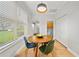 Cozy dining area with pendant lighting, wood floors, and views of the landscaped yard at 18004 Avalon Ln, Tampa, FL 33647