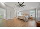 Spacious main bedroom with light wood floors, ceiling fan, and lots of natural light from the two windows at 18004 Avalon Ln, Tampa, FL 33647