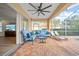 Covered brick patio with comfortable seating, ceiling fan, and views of the pool and outdoor space, screened for comfort at 18004 Avalon Ln, Tampa, FL 33647