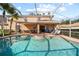 Resort-style pool and spa with outdoor seating area, perfect for relaxation and entertainment under a screened enclosure at 18004 Avalon Ln, Tampa, FL 33647