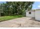 Expansive concrete backyard with partial grass and mature trees, perfect for outdoor activities at 1826 Cadillac Cir, Tampa, FL 33619