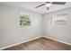 Well-lit bedroom with wood-look floors, two windows, and neutral walls at 1826 Cadillac Cir, Tampa, FL 33619