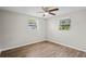 Bright bedroom with hardwood floors, ceiling fan, and two sunny windows at 1826 Cadillac Cir, Tampa, FL 33619