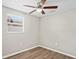 Bright bedroom featuring wood floors, a ceiling fan, and a large window at 1826 Cadillac Cir, Tampa, FL 33619